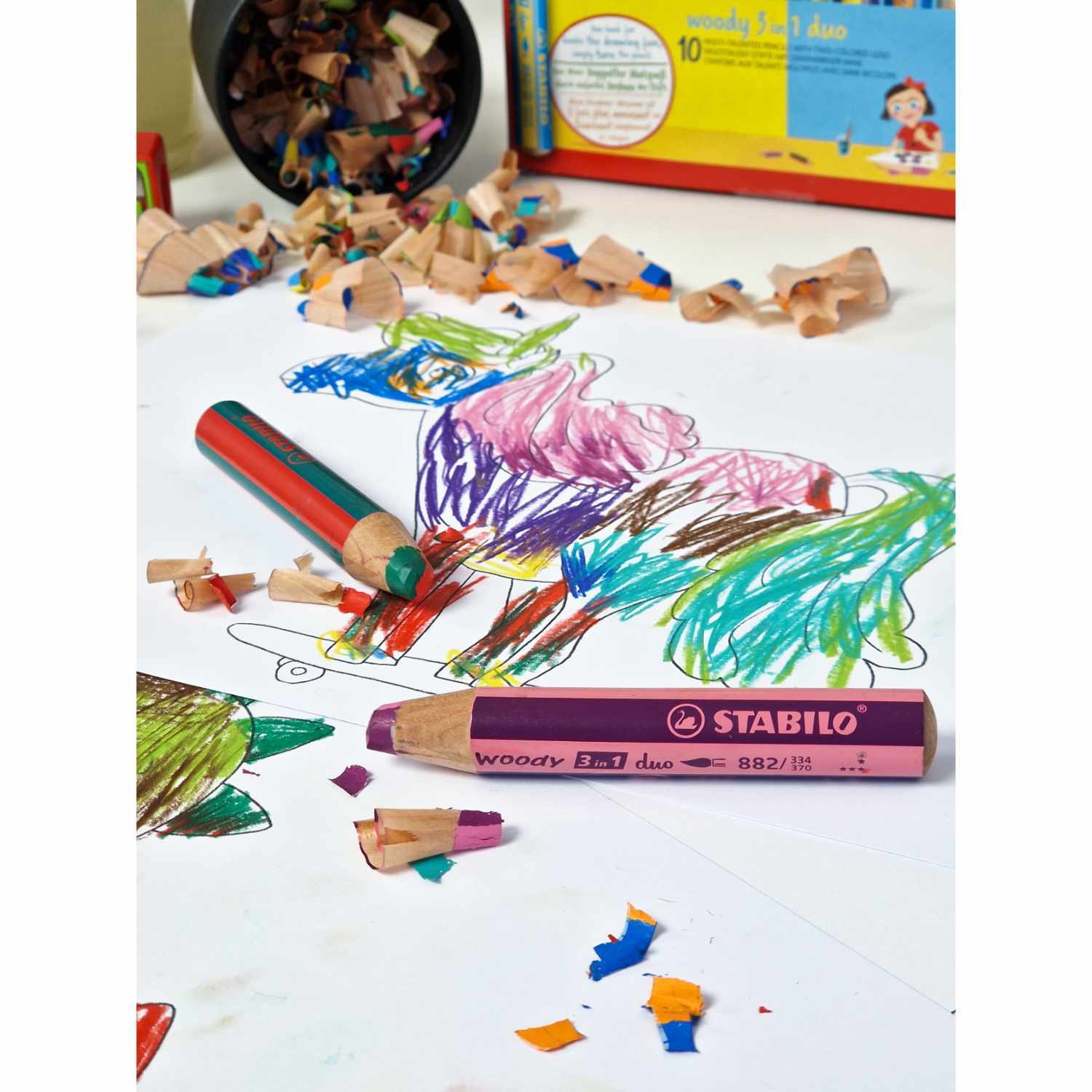 Woody Duo mit Spitzer im Etui 5 Stück: Bunte Stifte von STABILO auf einem Tisch mit Kinderzeichnung und Spitzer.