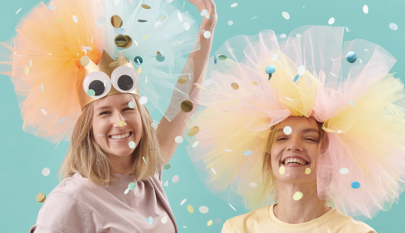 Bastelanleitung Karnevalskrone mit Tüll: Zwei Frauen tragen bunte Tüllkronen, umgeben von Konfetti.