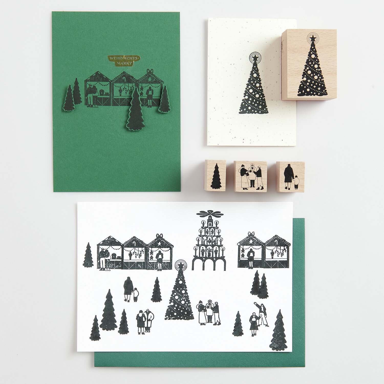 Stempelset Weihnachtsmarkt, 12-teilig, zeigt Weihnachtsmotive auf Karten und Holzstempeln.