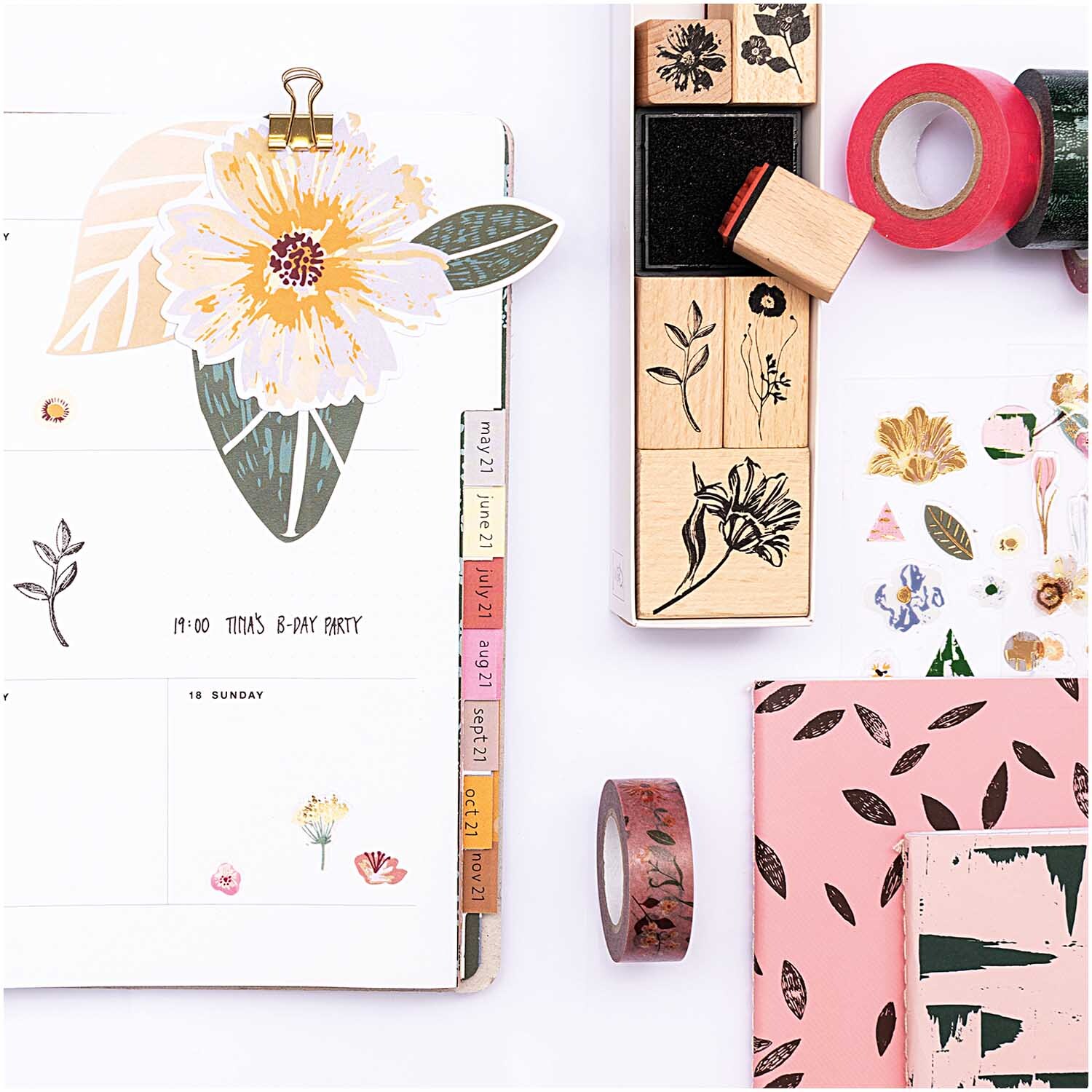 Paper Poetry Papieranhänger Blätter, dekoriert mit floralen Motiven und Bastelmaterialien auf einem Schreibtisch.