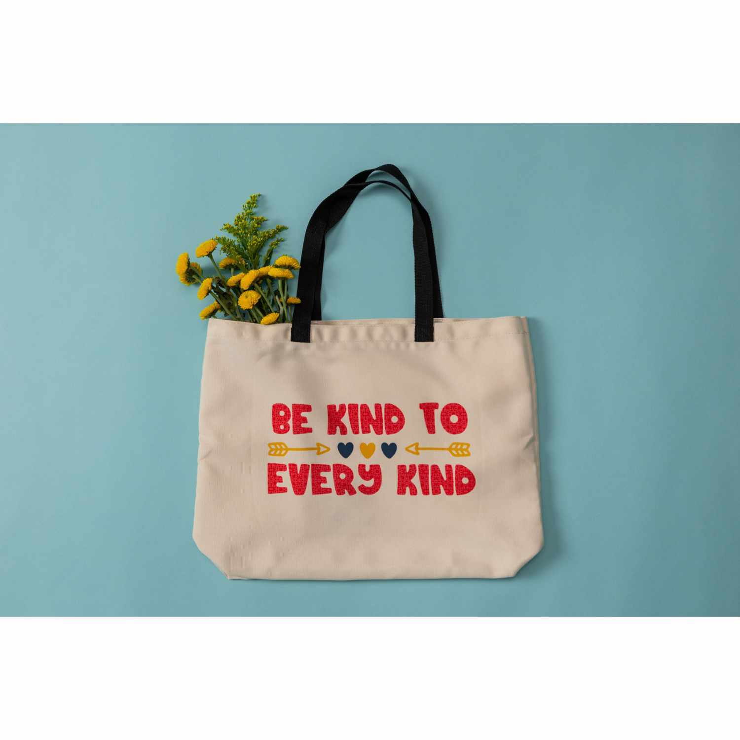 Einkaufstasche natur 35,5x35,5cm mit schwarzem Griff und Aufschrift "Be Kind to Every Kind" auf blauem Hintergrund.