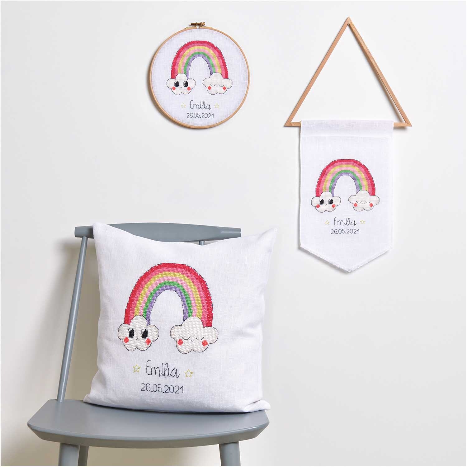 Stickring mit Regenbogenmotiv und Wolken, dekorativ auf einem Stuhl platziert, 18 cm Durchmesser.