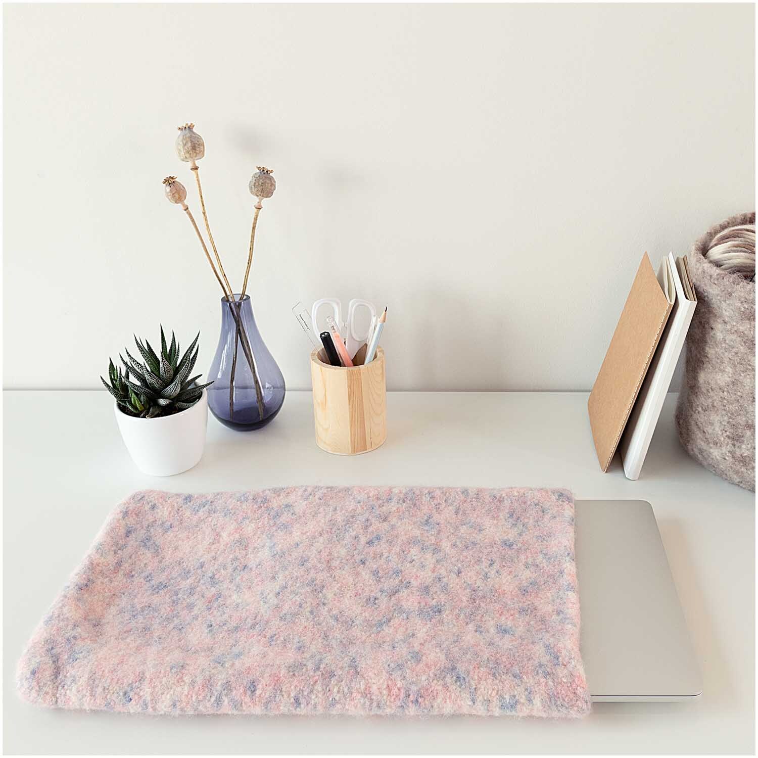 Creative Filz Print: Weiche Filzhülle in Lachs Color auf einem Schreibtisch mit Pflanzen und Schreibutensilien.