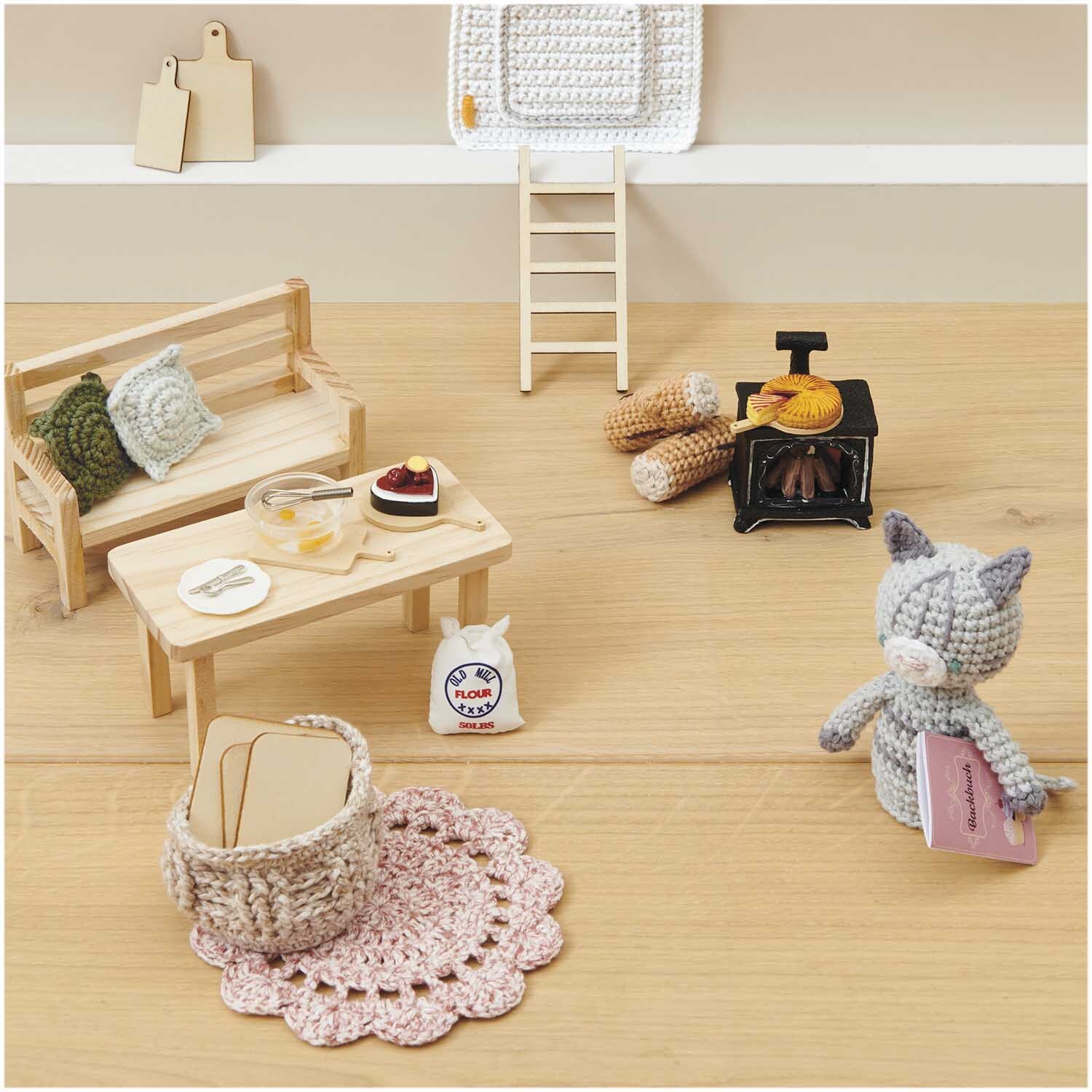 Miniatur Kuchen Herz: Gemütliche Puppenhaus-Szene mit Ofen, Bank, Tisch und gestrickter Katze.