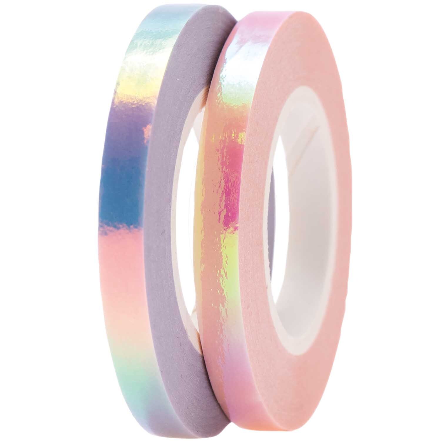 Paper Poetry Tapes irisierend 5mm 10m 2 Stück von Rico Design in Rosa-Flieder, zwei Rollen schimmerndes Klebeband auf schwarzem Hintergrund.