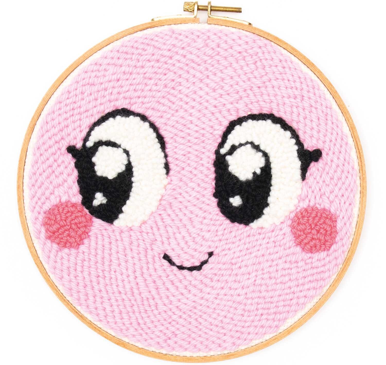 Punch Needle Packung Loco Loco Gesicht rosa zeigt ein lächelndes Gesicht mit großen Augen.