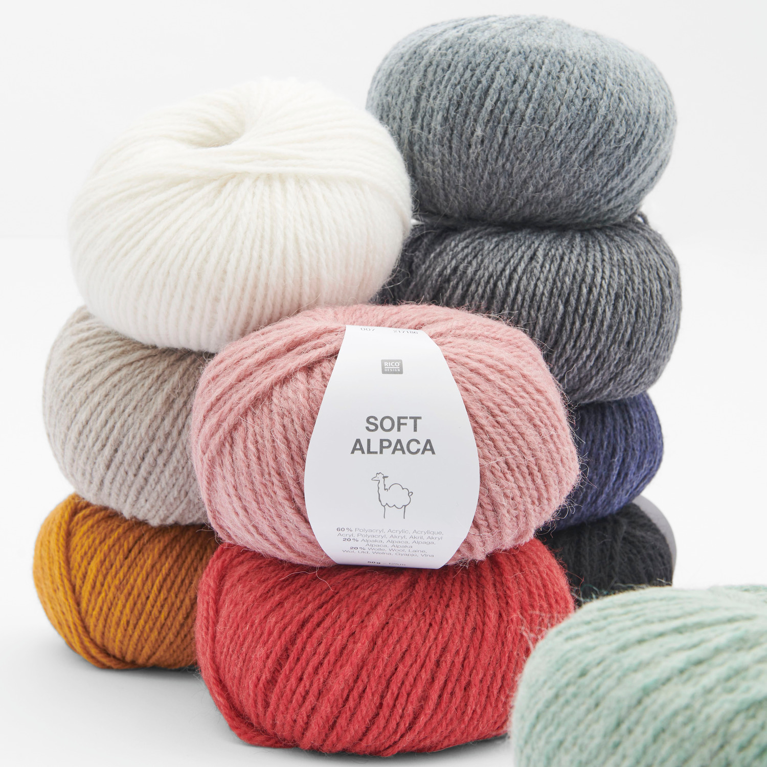 Soft Alpaca Wolle von Rico Design in verschiedenen Farben wie Rosa, Rot und Creme, gestapelt. Ideal für Strickprojekte, 50g 125m.