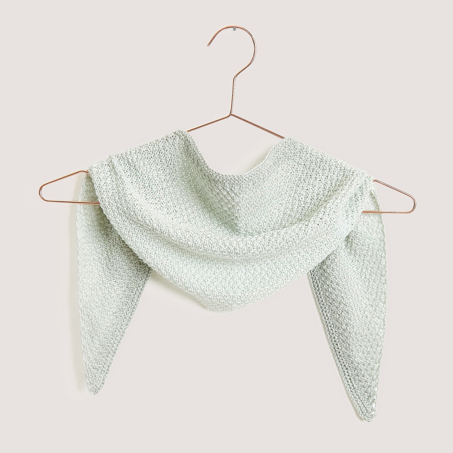 Creative Cotton Dégradé Lucky 8: Dreieckstuch in zartem Grün, drapiert auf einem Kleiderbügel. Perfekt für stilvolle Strickprojekte.