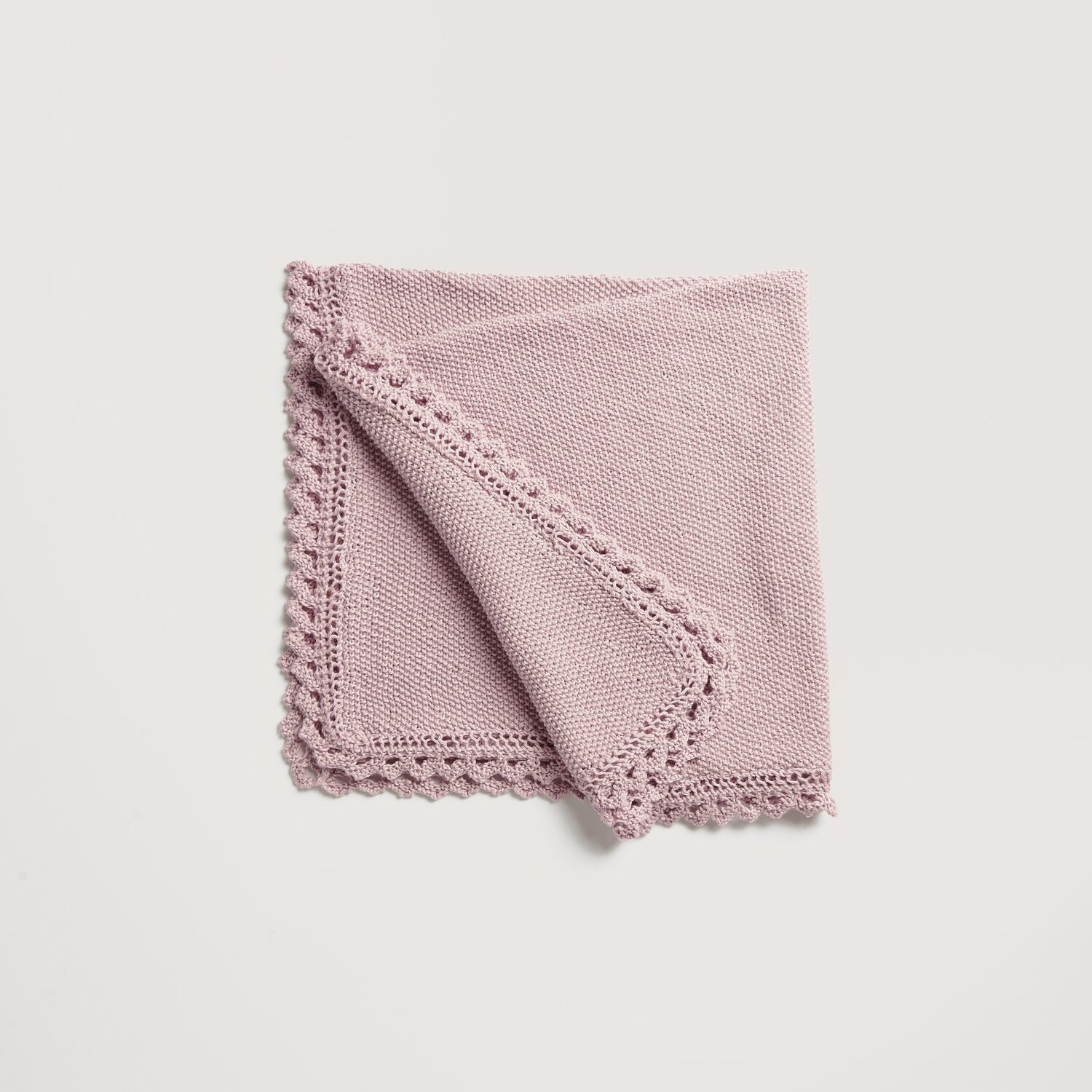 Strickset Babydecke Modell 02 in Flieder, aus Rico Baby Cozy Organic Cotton Cashmere, zeigt feine Strickmuster und zarte Kantenverzierungen.