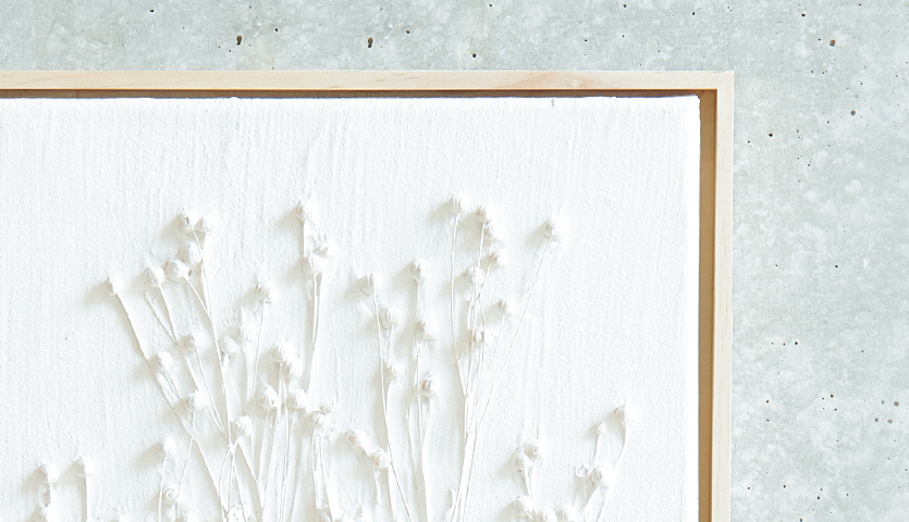 Anleitung Leinwand mit Strukturpaste und Trockenblumen gestalten: Weiße Leinwand mit zarten Trockenblumen auf strukturiertem Hintergrund.