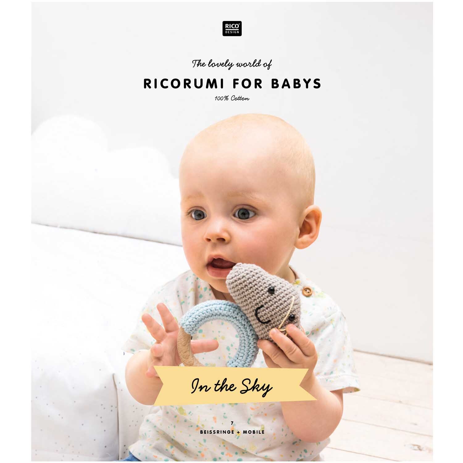 Ricorumi Baby In the Sky: Ein Baby hält ein gestricktes Spielzeug in Pastellfarben, ideal für die Kinderzimmerdekoration.