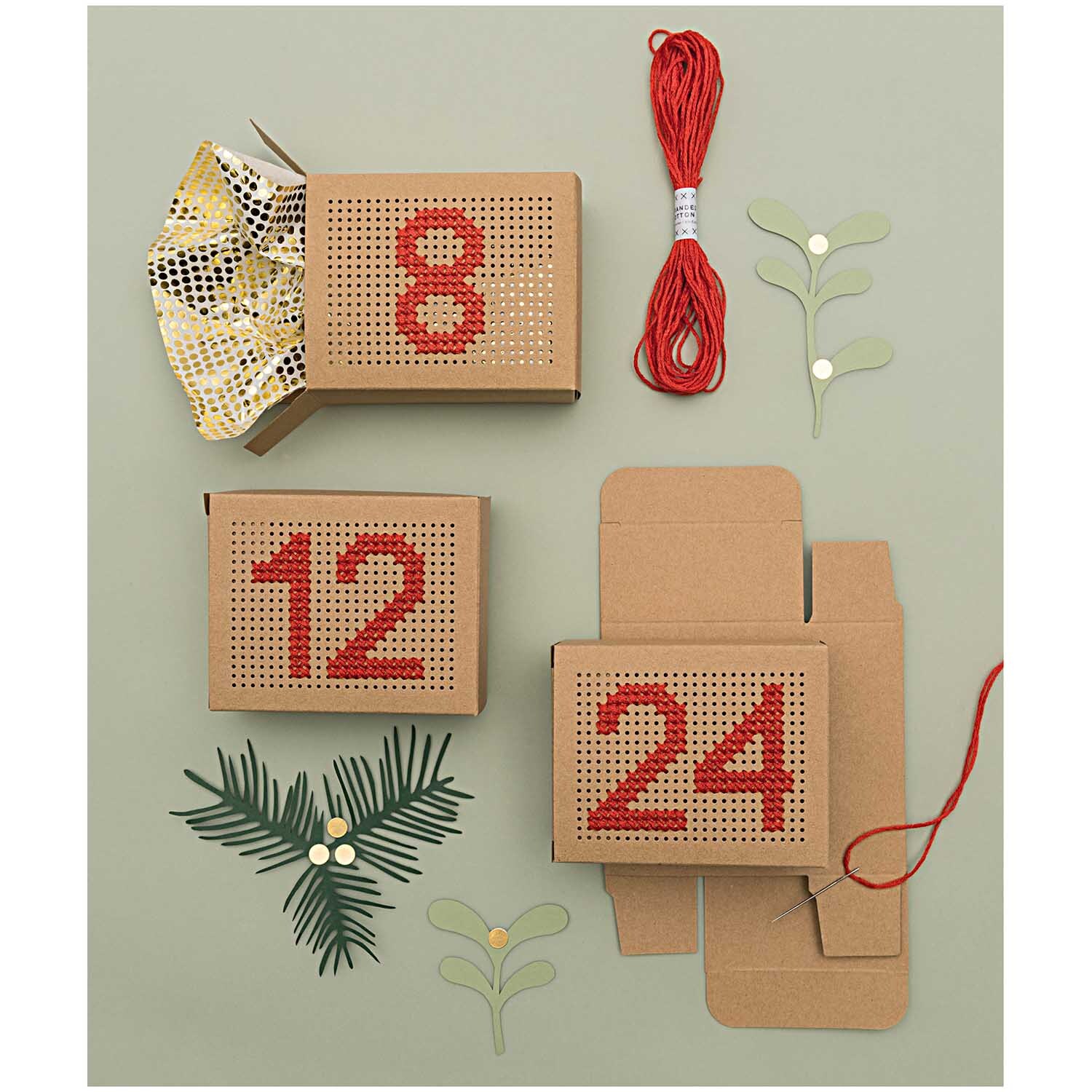 Paper Patch Papier Dots gold 30x42cm Hot Foil zeigt Adventskalenderboxen mit roten Zahlen und Dekorationen.