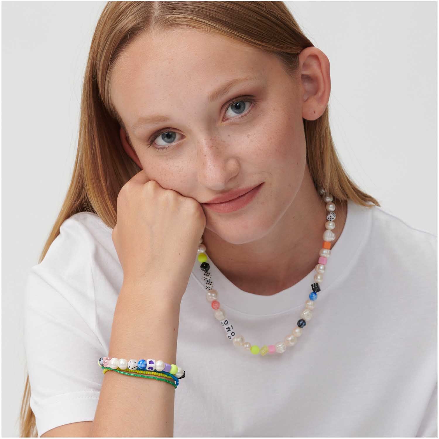 Itoshii Tie-dye Perlenkette in multicolor, getragen von einer Frau in weißem T-Shirt, Marke Rico Design.
