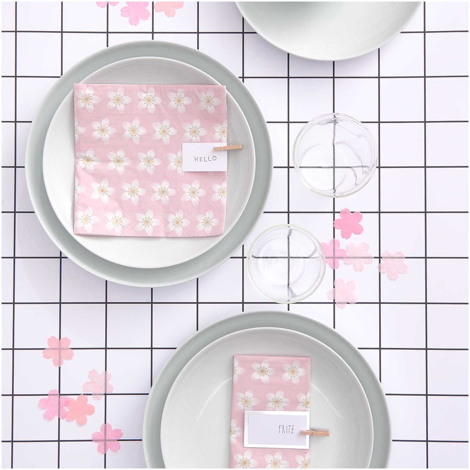 Servietten Kirschblüten rosa 33x33cm 20 Stück auf einem gedeckten Tisch mit weißem Geschirr und rosa Blütenmuster, von Rico Design.