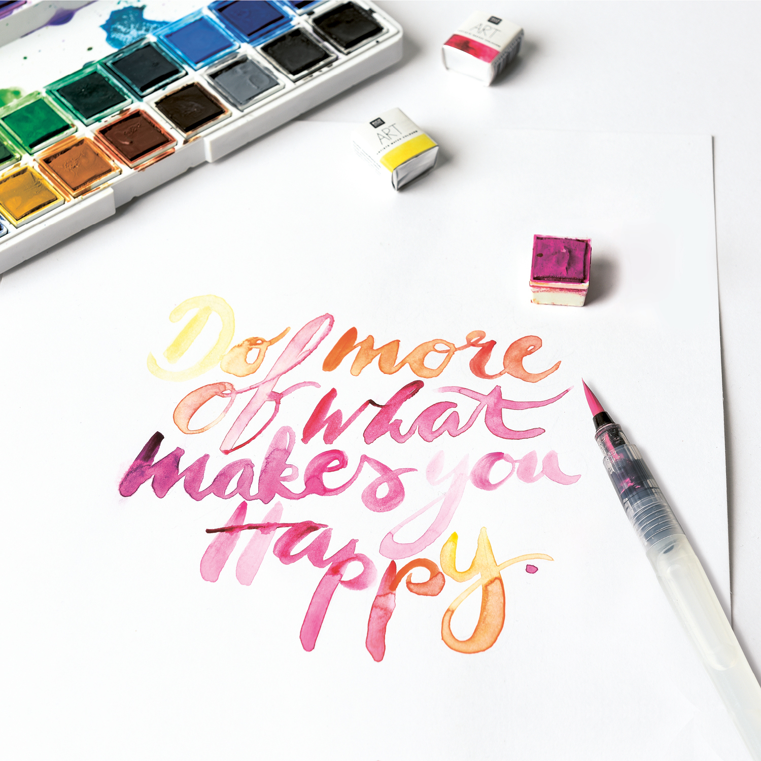 Anleitung Watercoloring Schriftzug mit der Blending-Technik, bunte Aquarellfarben und Pinsel.
