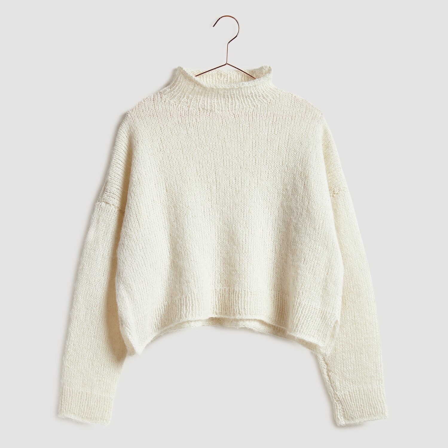 Gestrickter Pullover in Beige auf Bügel