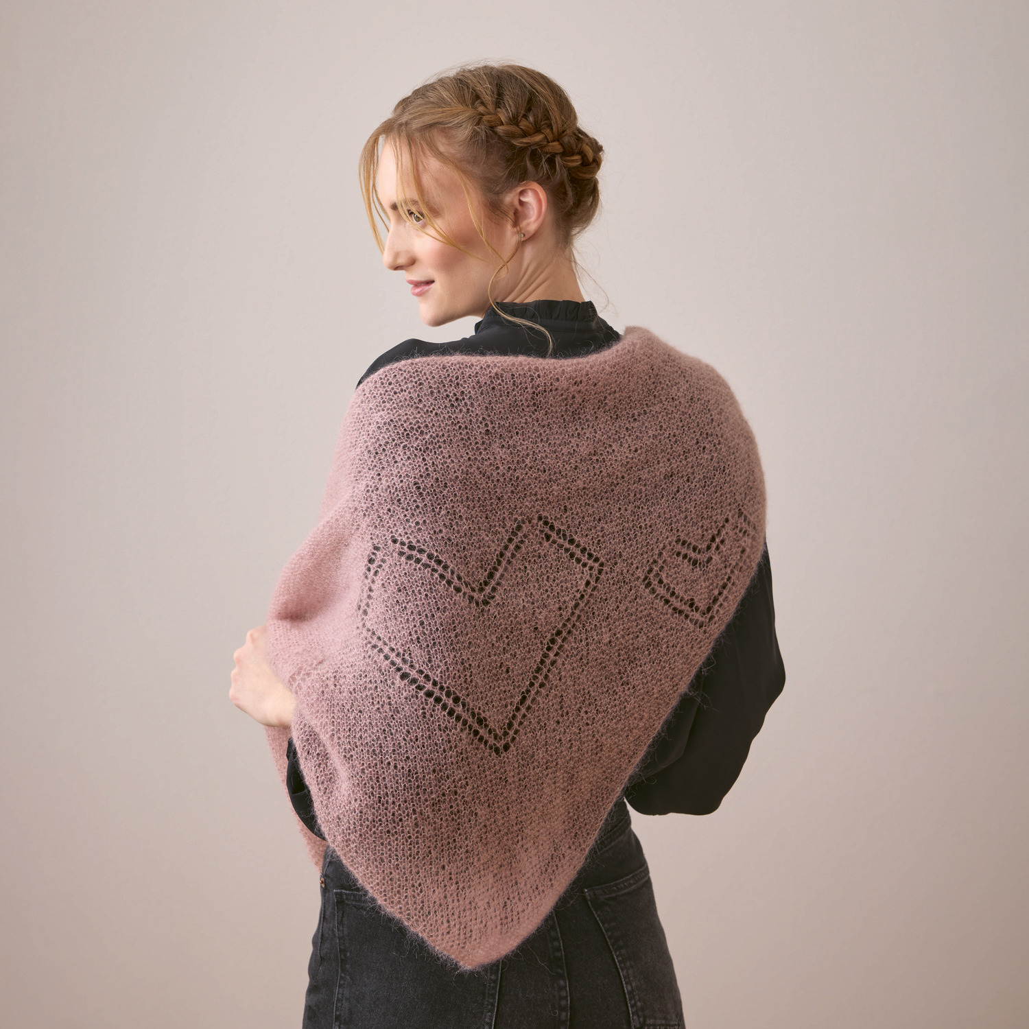 Strickset Dreieckstuch Modell 19: Frau trägt ein zartrosa Tuch mit Herzmuster, elegant drapiert.