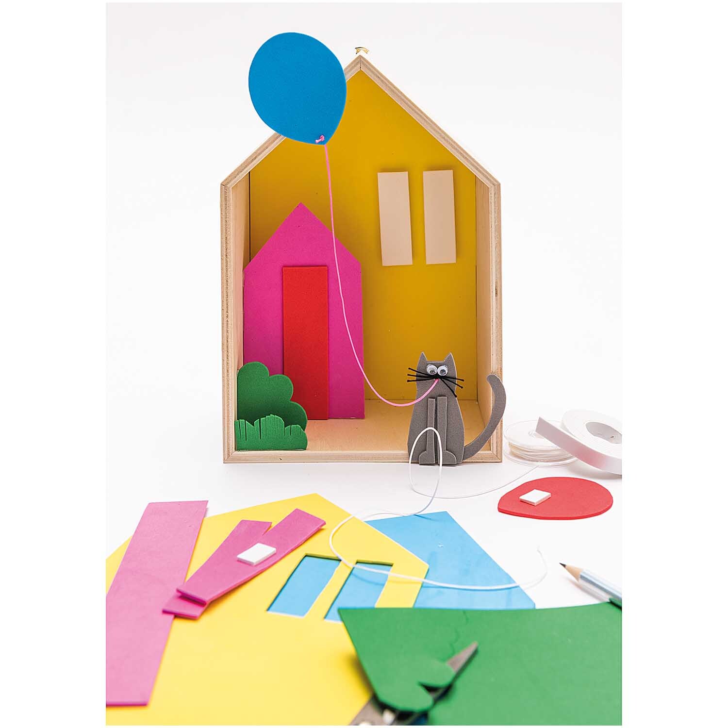 Moosgummi Mix 2mm 20x30cm 10 Platten: Bunte Bastelmaterialien vor einem Miniaturhaus mit Katze und Ballon.