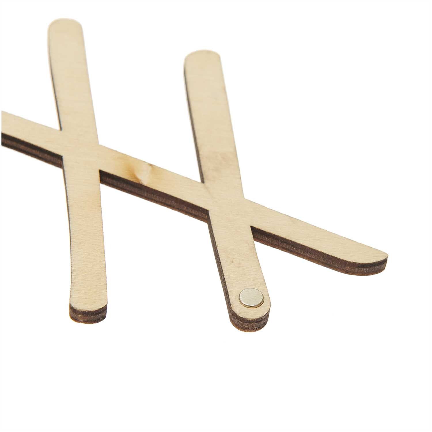 Holzschriftzug magnetisch "Home" 28x9cm von Rico Design, zeigt zwei überkreuzte Holzstäbe mit Magnet.
