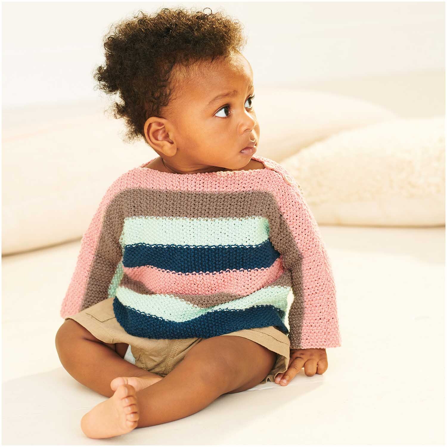 Baby Organic Cotton: Ein Baby trägt einen gestreiften Pullover aus Bio-Baumwolle von Rico Design.