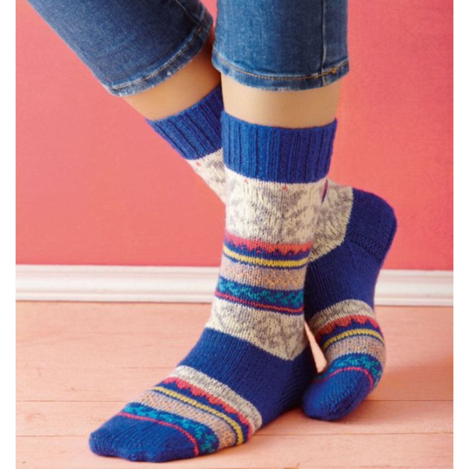Das ultimative Socken-Strickbuch: Bunte gestrickte Socken in Blau und Grau auf Holzboden.