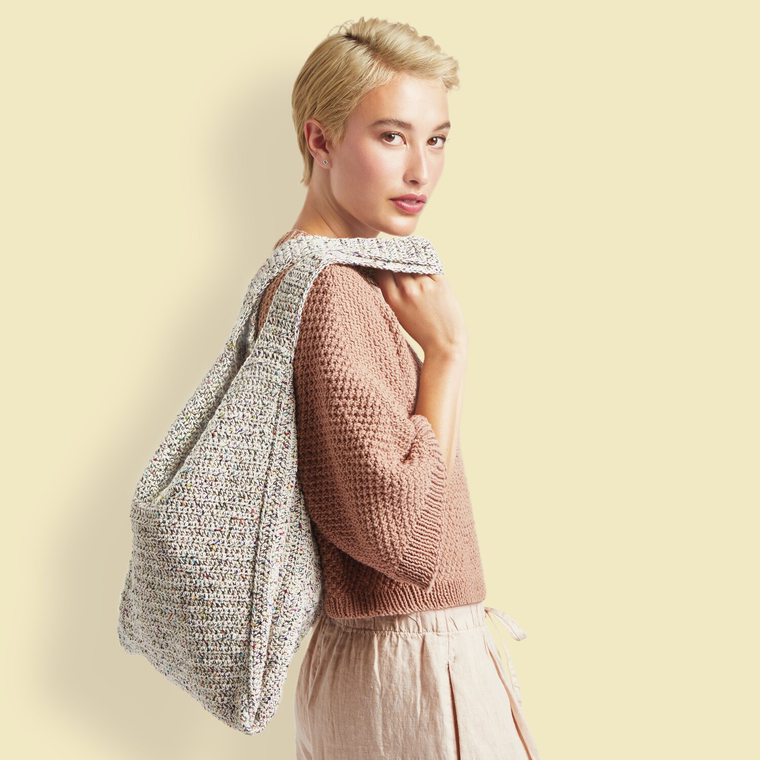 Made by Me No. 20 Frühjahr-Sommer: Frau mit gestricktem Beutel aus Essentials Organic Cotton von Rico Design, in natürlichen Farbtönen.