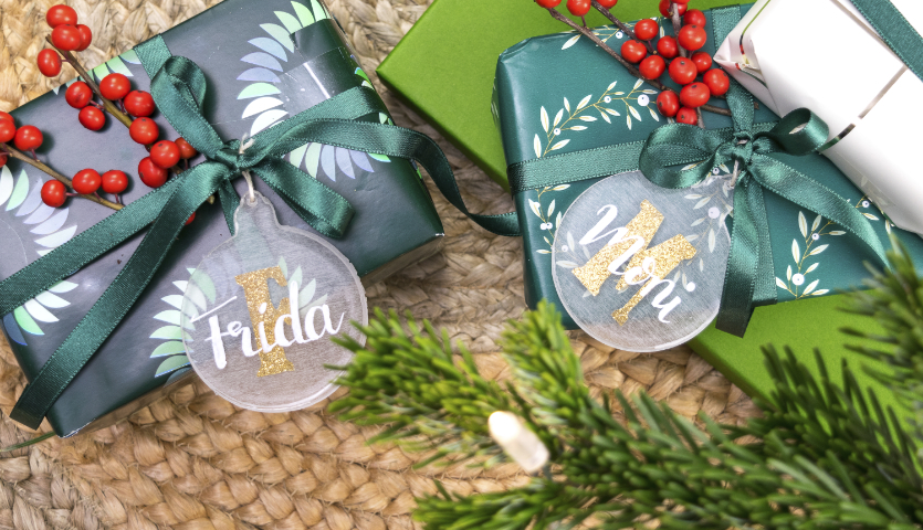 Bastelanleitung Geschenkanhänger aus Resin: Zwei festlich verpackte Geschenke mit personalisierten Resin-Anhängern und grünen Schleifen.