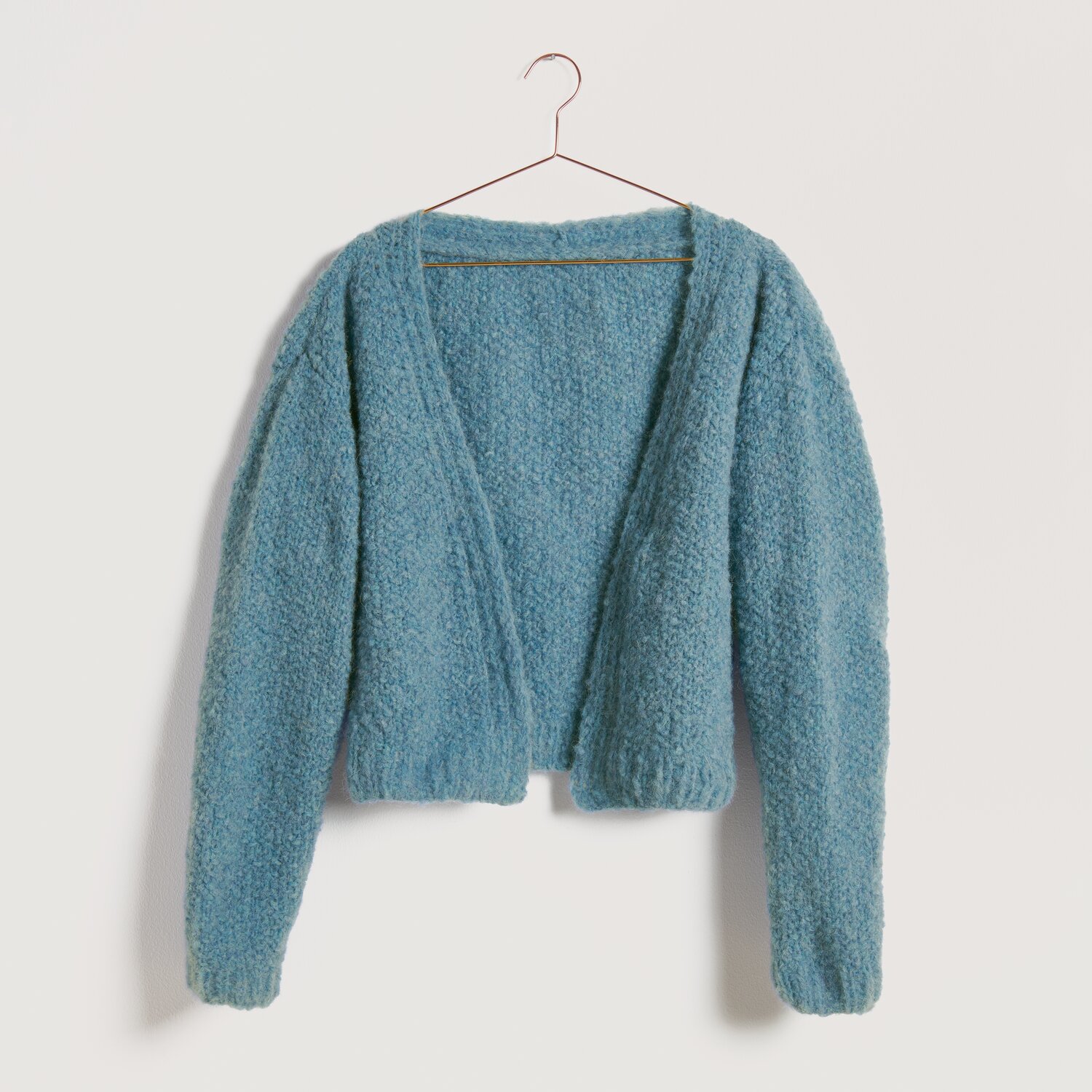 Strickset Kimonojacke Modell 18b aus Die Neue Masche No. 10, flauschige blaue Jacke auf einem Kleiderbügel vor hellem Hintergrund.
