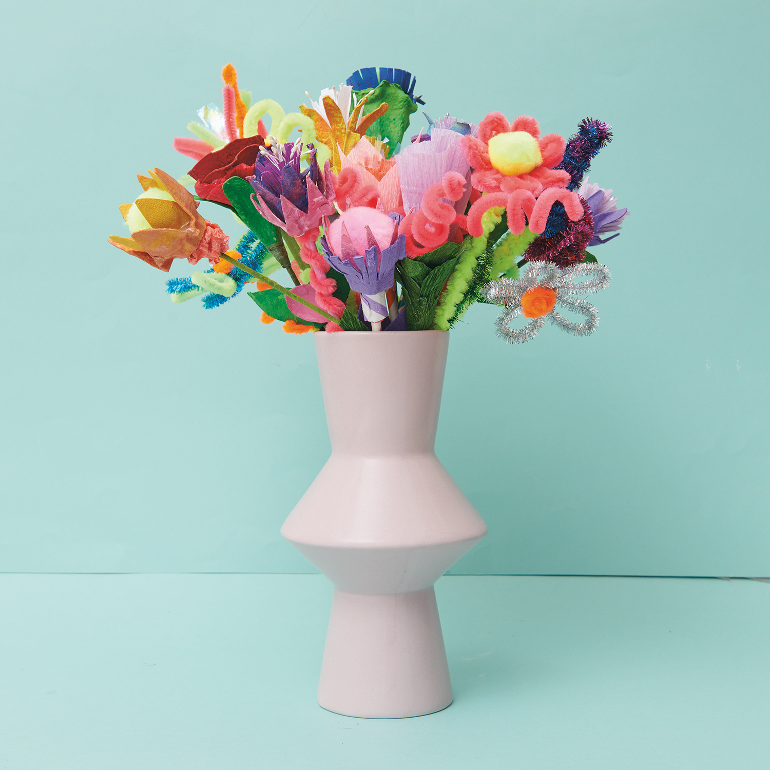 Bastelanleitung Blumen aus Eierkarton: Bunter Strauß aus Eierkartonblumen in modernem, weißem Keramikvase.
