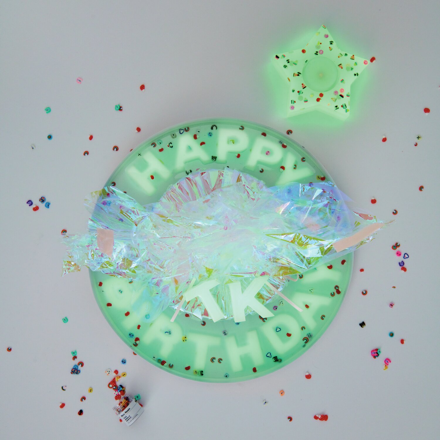 Farbpigmente für Resin Neon nachtleuchtend in leuchtendem Gelb, umgeben von buntem Konfetti und einem leuchtenden Stern.