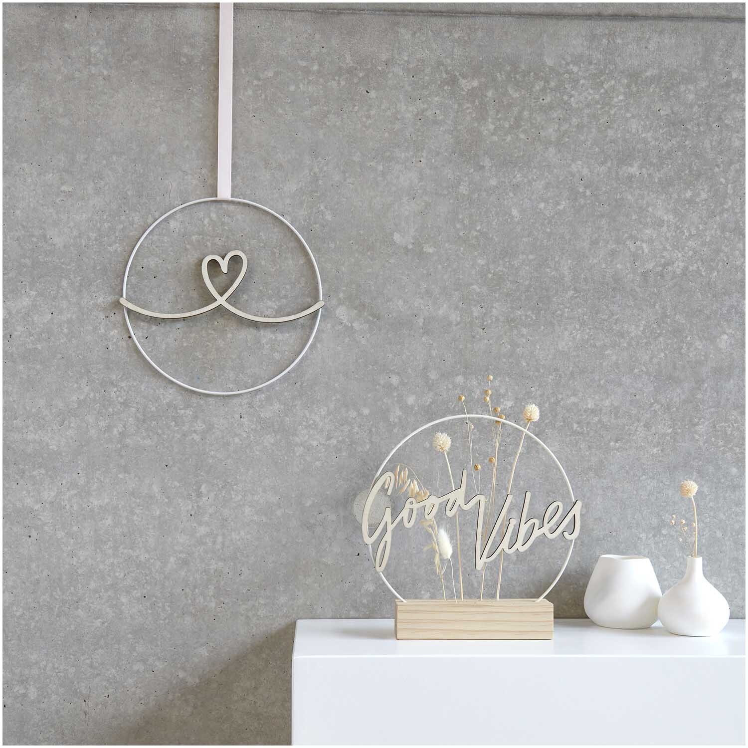 Holzschriftzug magnetisch "Herz" 29x11cm von Rico Design auf grauer Wand mit Dekoration.