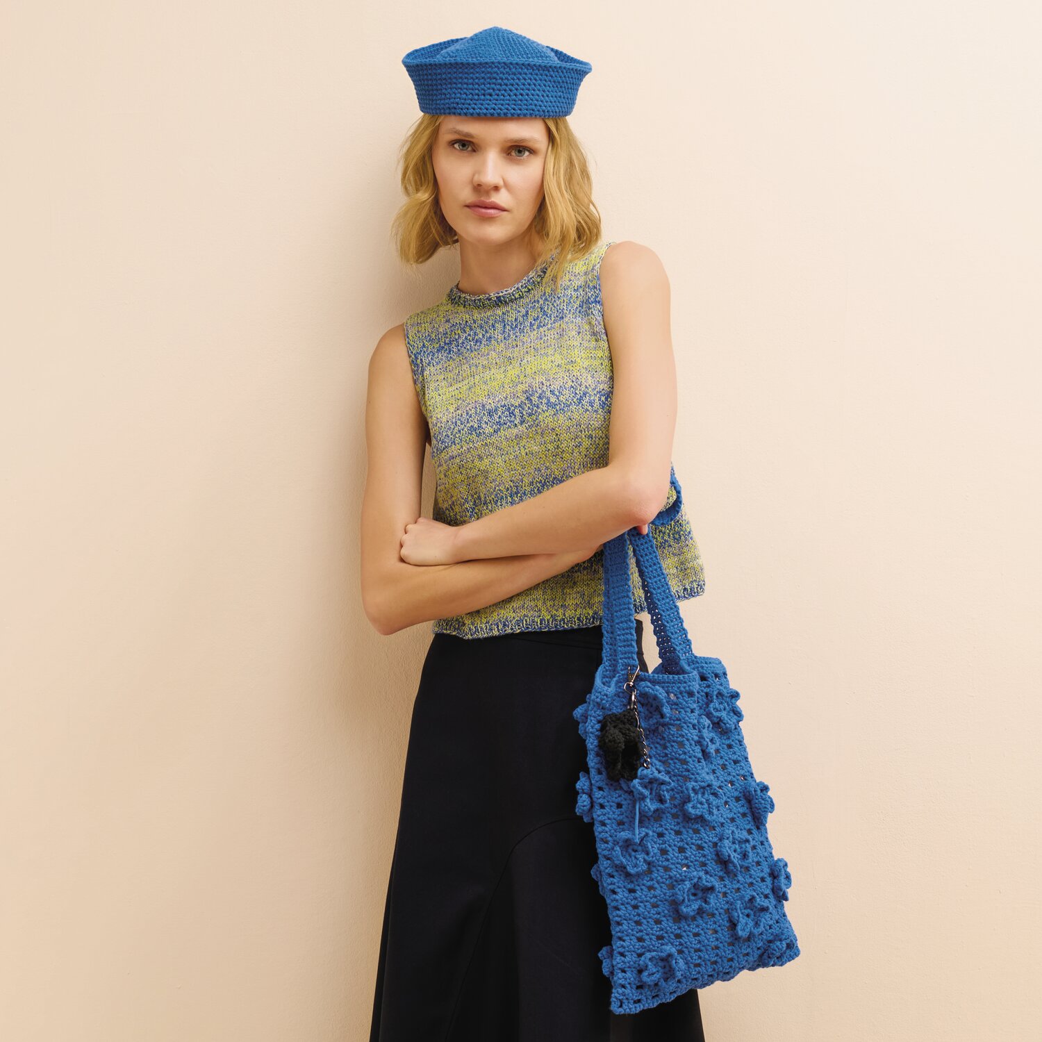 Häkelset Sailor-Hat Modell 02 aus Made by Me No. 22, getragen von Frau mit passender, strukturierter Häkeltasche, kombiniert mit ärmellosem Oberteil und weiter Hose