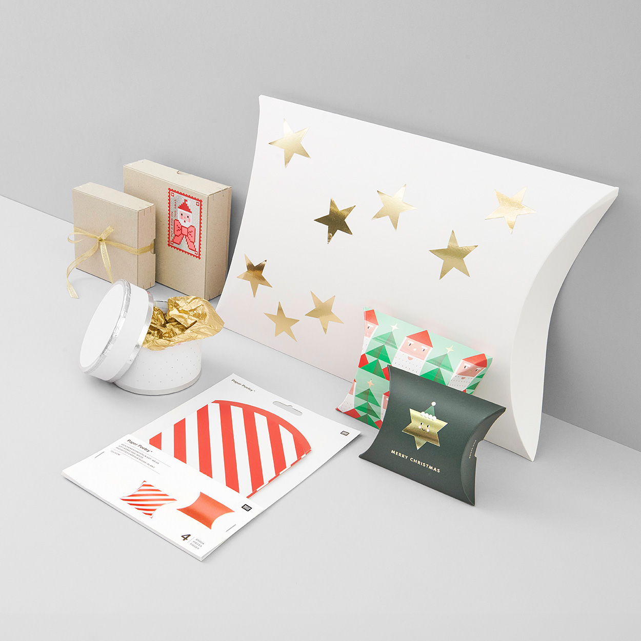 Geschenkschachteln mit weihnachtlichen Motiven und in unterschiedlichen Formen. Fotosetting graue Ecke.