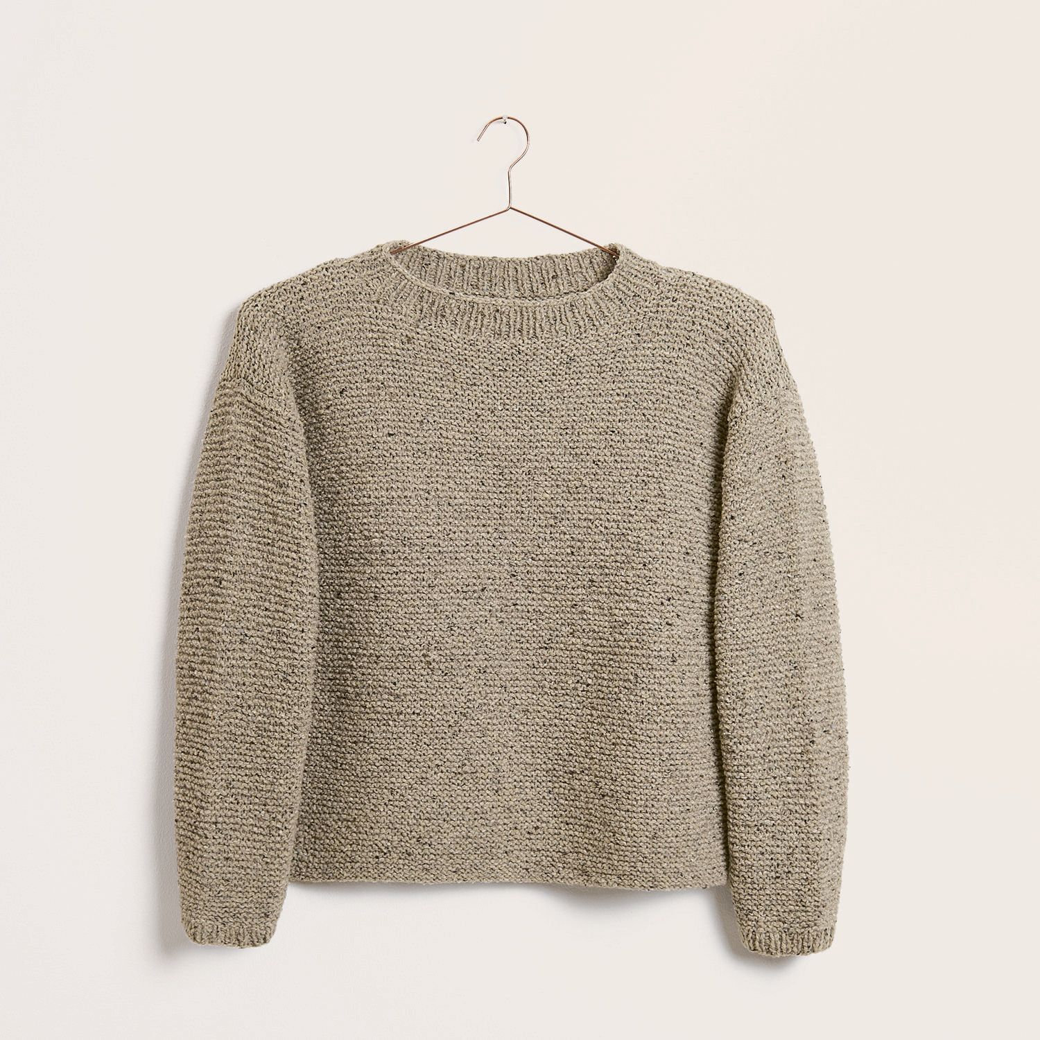 Strickset Pullover Modell 04 aus Trachtenbuch I mog di, naturfarben, auf einem Kleiderbügel.