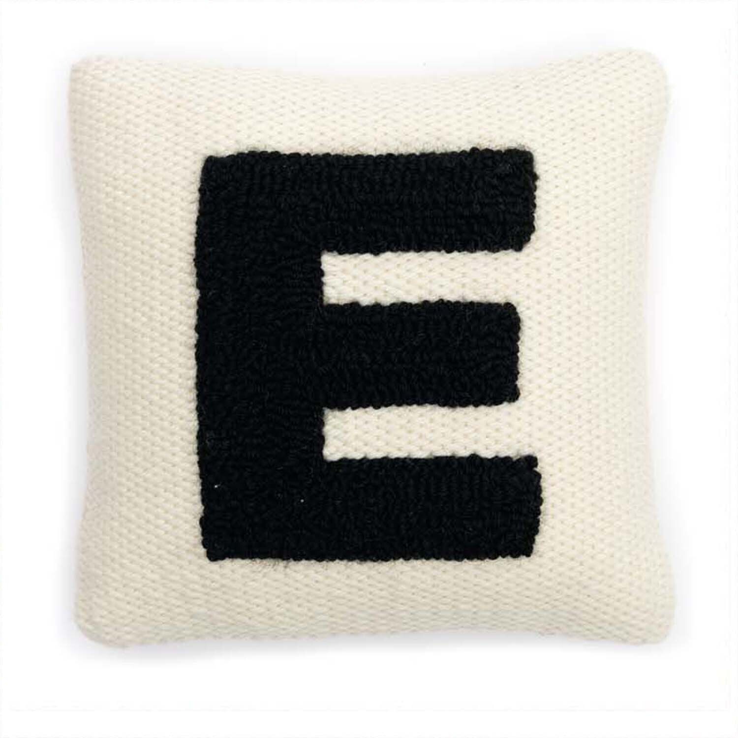 Punch Needle Packung Kissen Alphabet zeigt ein weißes Kissen mit einem großen schwarzen Buchstaben E. Marke: Rico Design.