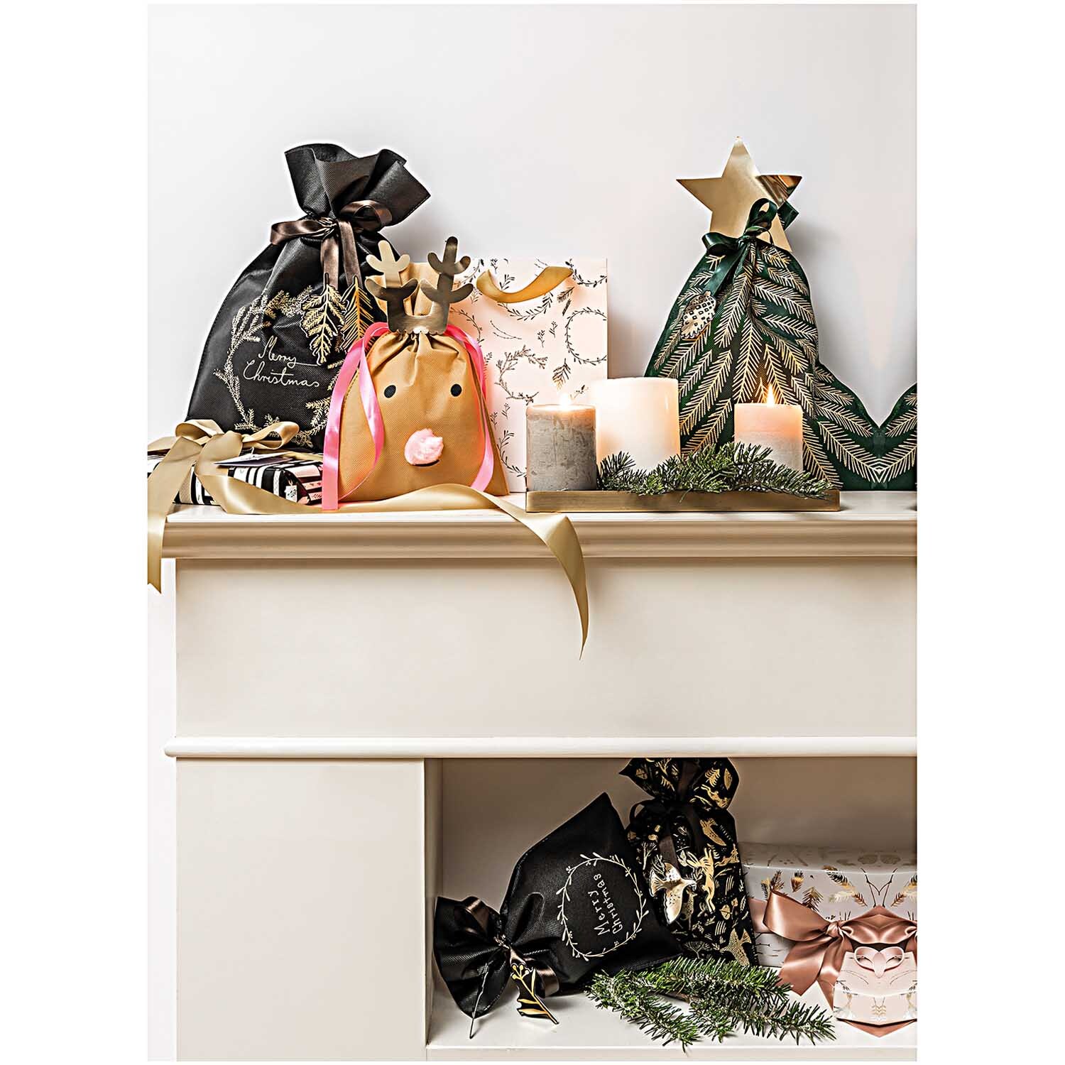 Paper Poetry Geschenktüte mit nostalgischem Weihnachtskranz in Schwarz, dekoriert auf einem Regal mit Kerzen und Geschenken.