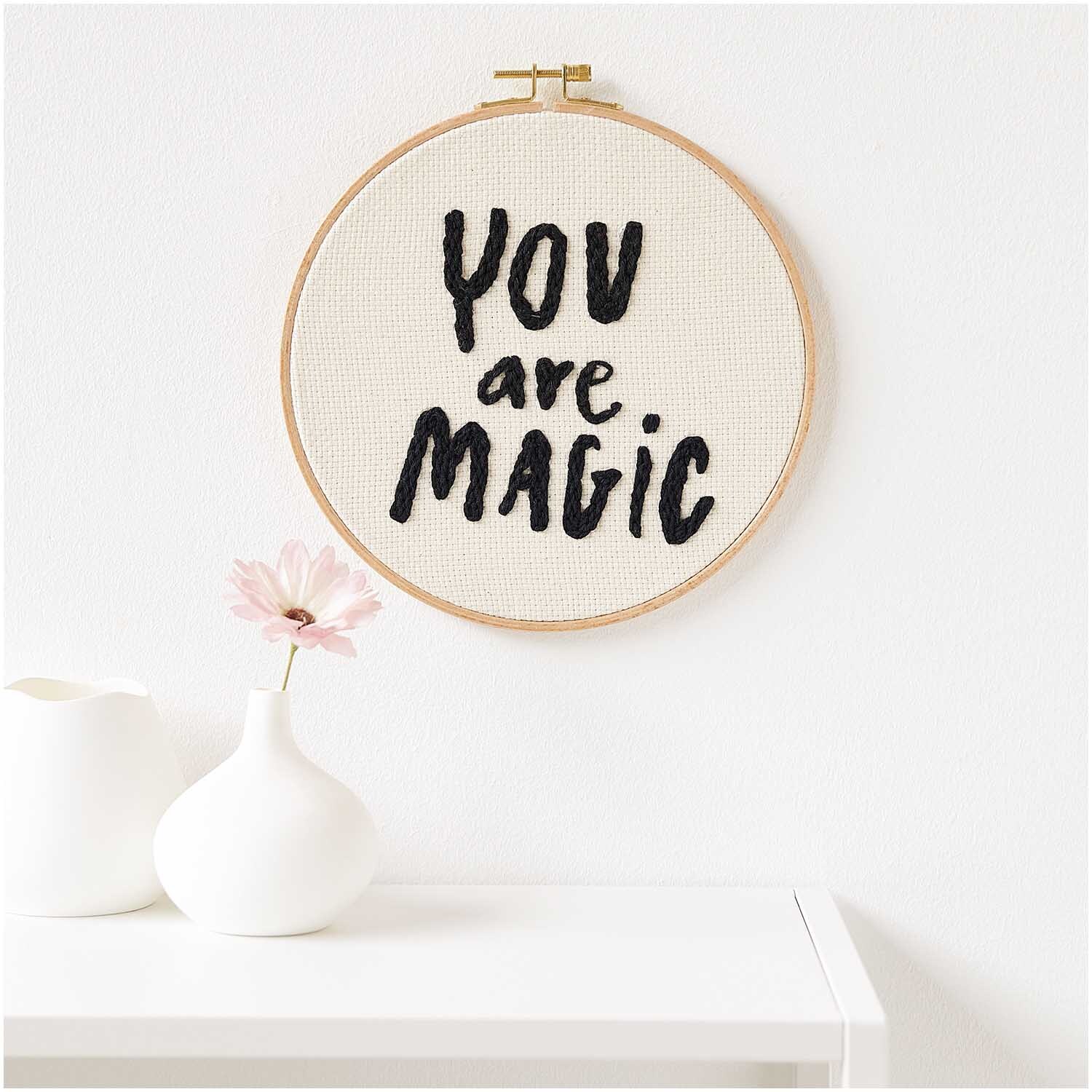 Punch Needle Packung Bild You Are Magic rund Ø21,5cm von Rico Design zeigt eine Stickerei in einem Holzrahmen mit inspirierendem Text.