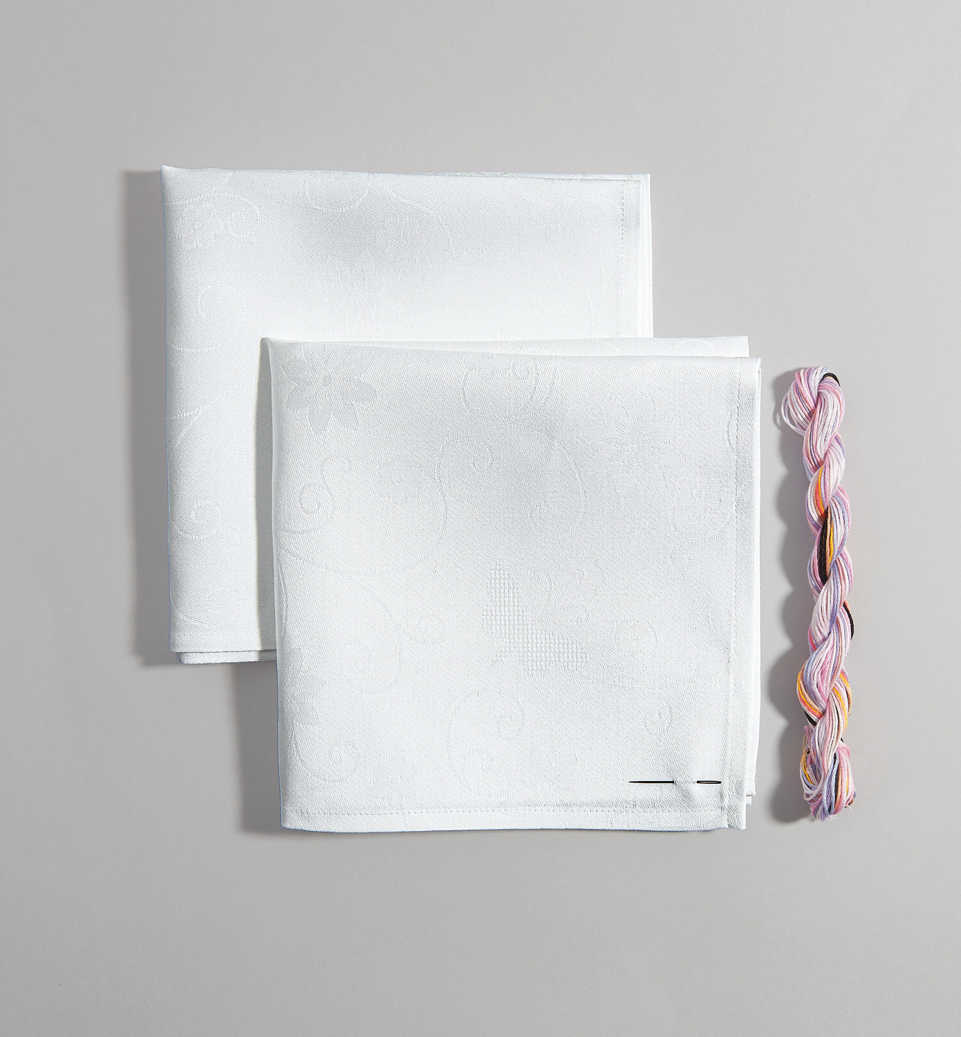 Stickpackung Servietten mit Schmetterlingen zeigt zwei weiße Servietten mit bunten Schmetterlingsmotiven von Rico Design, Größe 42x42cm.