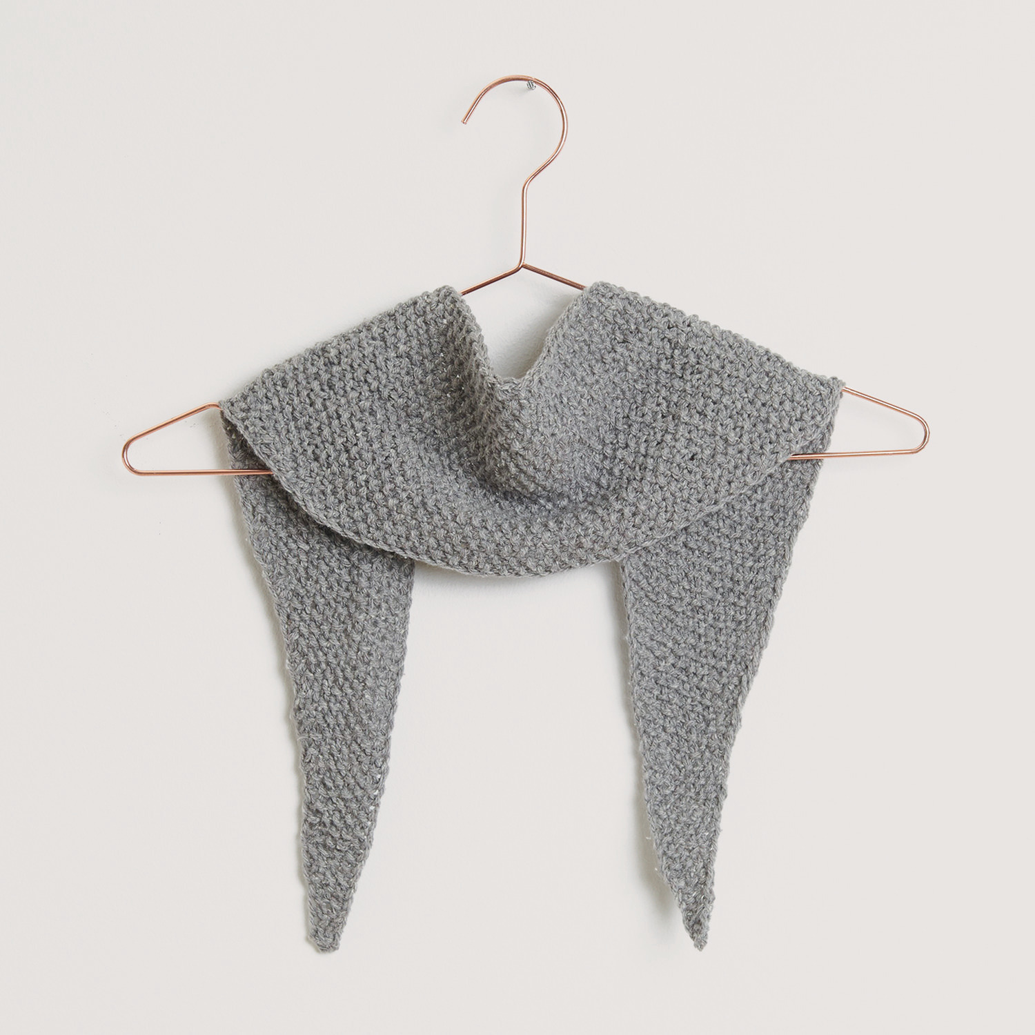 Luxury Natural Silk Blend, gestricktes graues Tuch von Rico Design, elegant drapiert auf einem Kleiderbügel. Ideal für stilvolle Akzente.