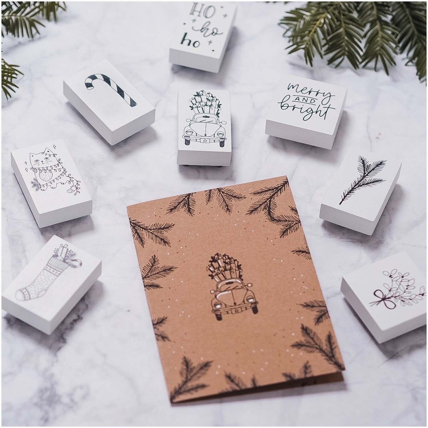 Stempel Schneekugel: Verschiedene weiße Stempel von May&Berry, darunter Schneekugel und Tannenbaum, auf Marmorhintergrund.