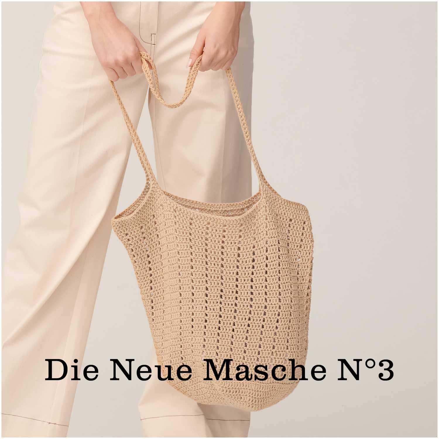 Cotton Universal: Eine beige Häkel-Tasche aus Wolle Rödel, präsentiert von einer Person in heller Kleidung.