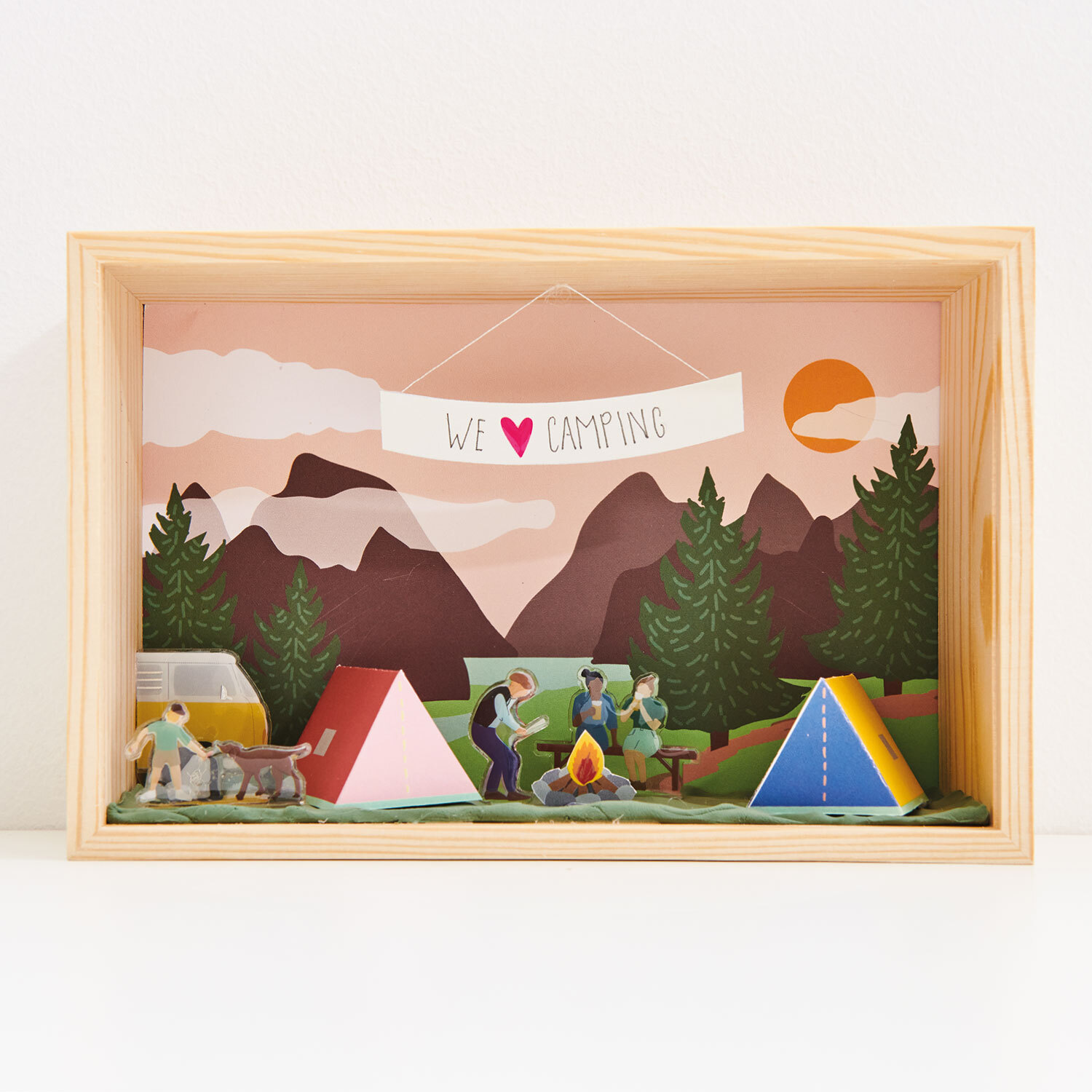 Bastelanleitung Figurico Camping: Diorama mit Zelten, Lagerfeuer und Figuren vor Bergkulisse.