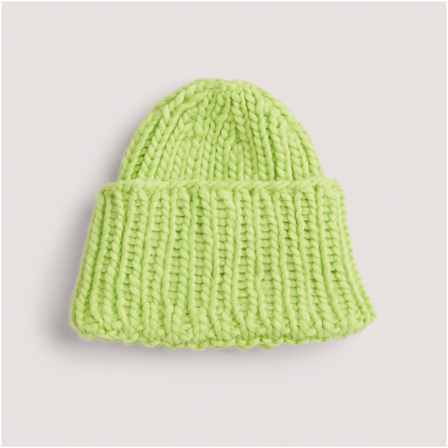 Strickset Mütze Modell 20: Leuchtend grüne, handgestrickte Mütze aus dicker Wolle, ideal für kalte Tage.