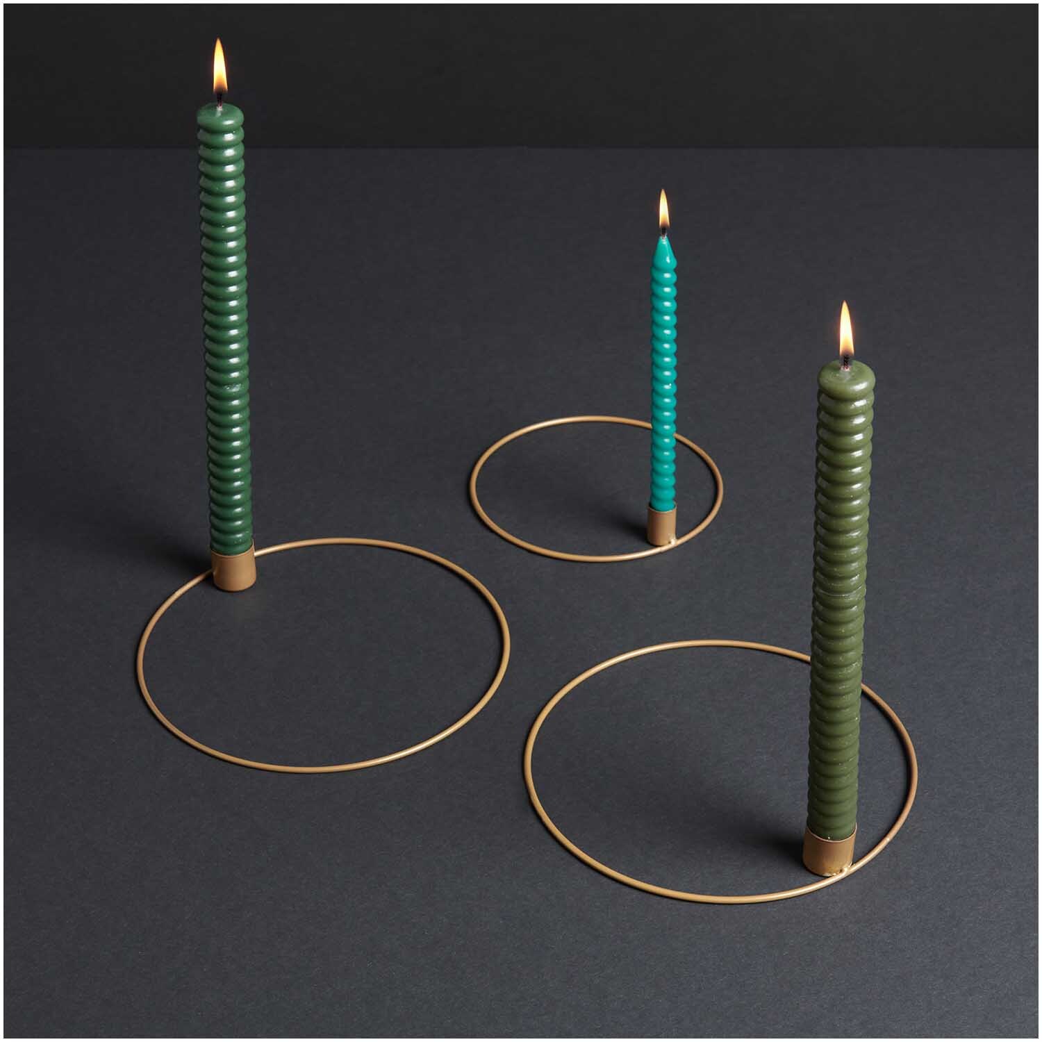 Metallring mit Kerzenhalter Ø 20cm in Gold Matt, präsentiert mit drei grünen Kerzen auf dunklem Hintergrund.