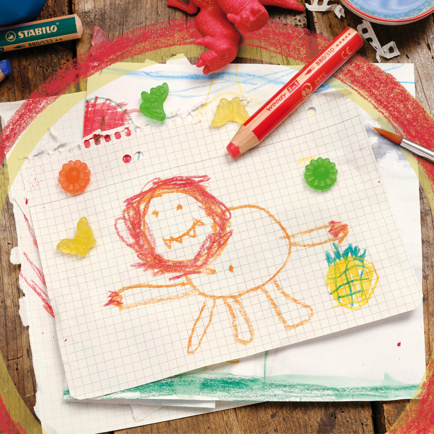 Woody Swano 3 in 1 im Etui: Buntstiftzeichnung eines Löwen auf kariertem Papier, umgeben von roten und grünen Gummitieren.