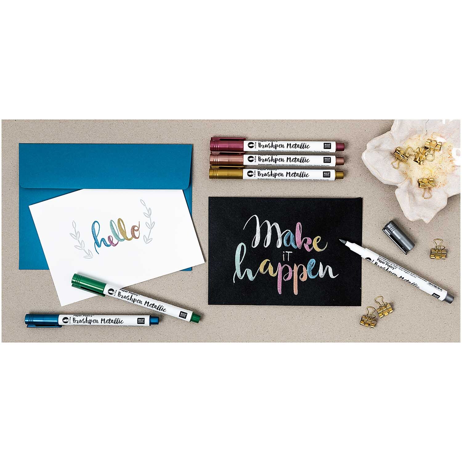 Paper Poetry Metallic Brushpens 6 Stück von Rico Design auf einem Tisch mit Karten und Clips.