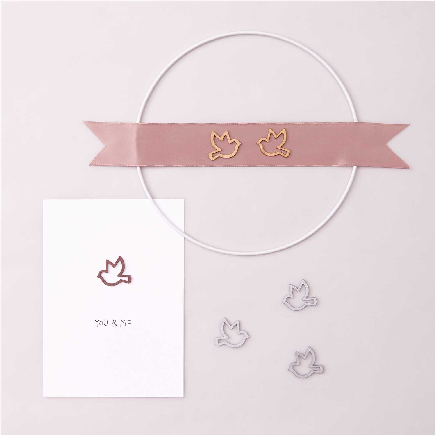 Holzstreu Taube offen 24 Stück von Rico Design in Roségold auf rosa Band mit Karte und Streuteilen.