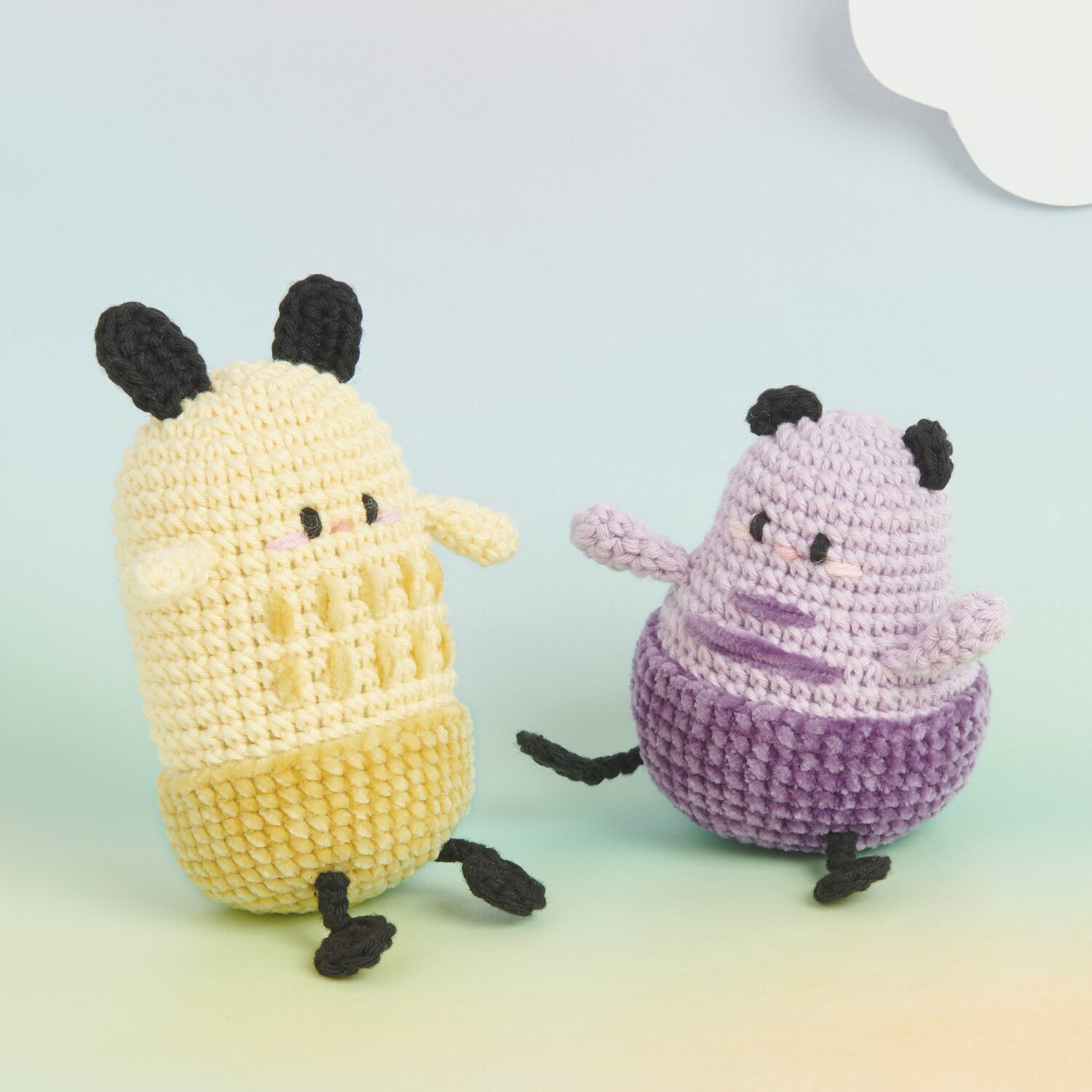 Ricorumi Rainbow Weirdos, gehäkelte Figuren in Vanille und Lila, mit schwarzen Details.
