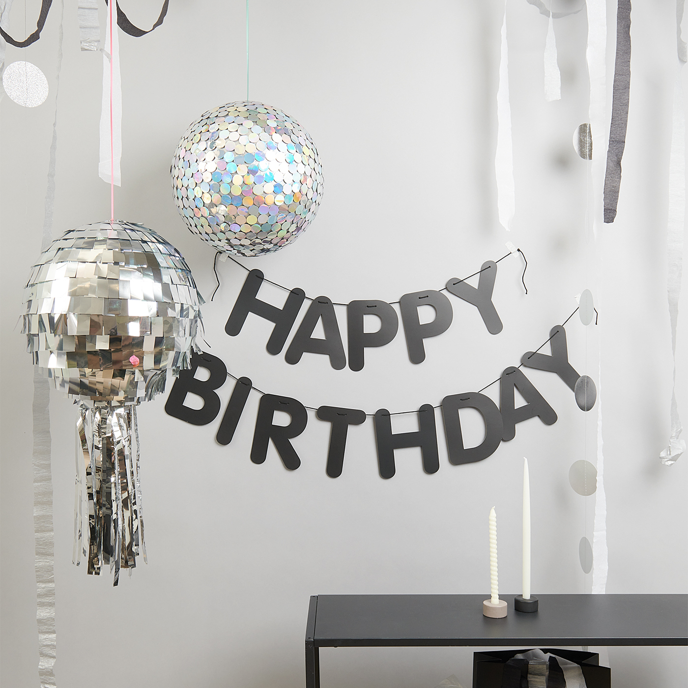 Bastelanleitung Diskokugel: Zwei schillernde Diskokugeln und ein "Happy Birthday"-Banner an der Wand.