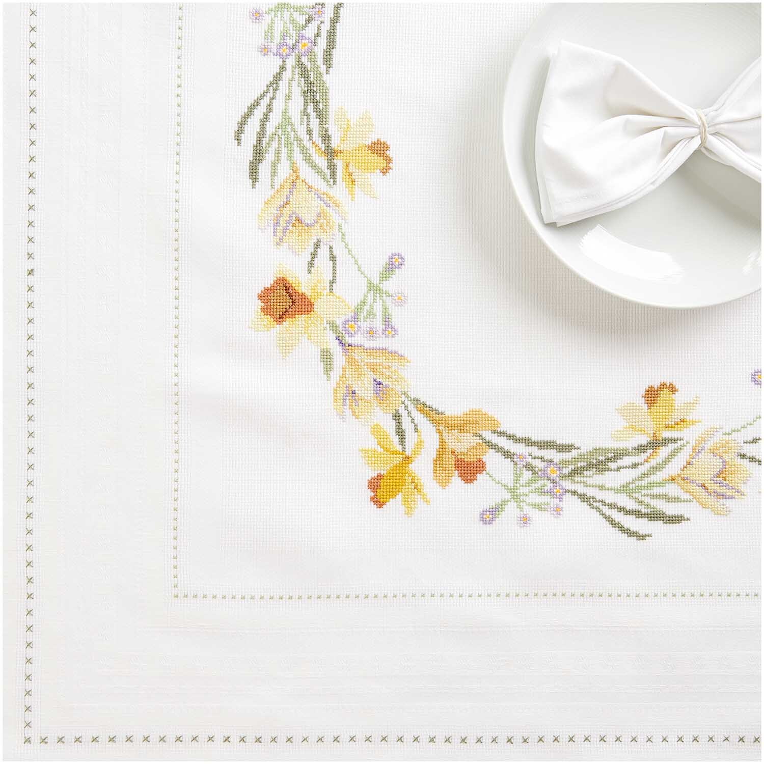 Stickpackung Tischdecke Frühlingskranz von Rico Design zeigt zarte Blumenstickerei auf weißem Stoff, ideal für Frühlingsdekorationen.